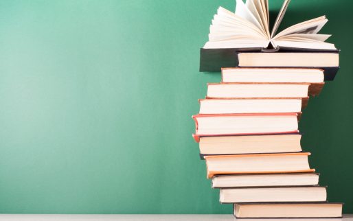 Open book, hardback books on wooden table. Education background. Back to school. Copy space for text