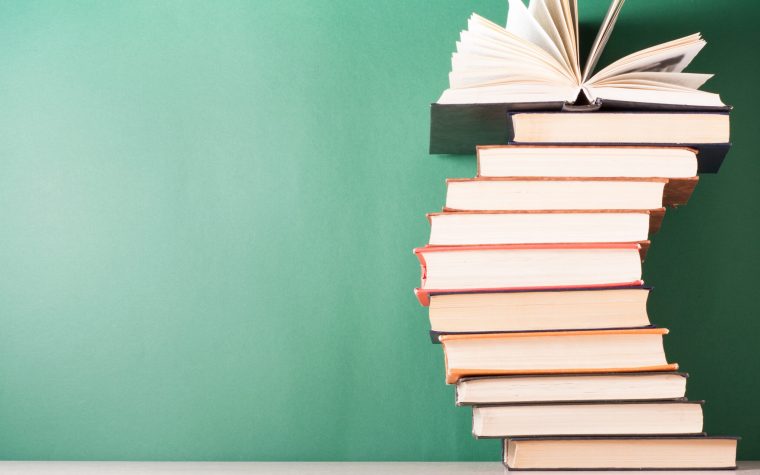 Open book, hardback books on wooden table. Education background. Back to school. Copy space for text