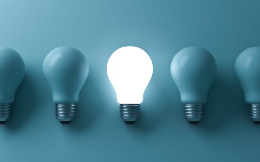 One glowing light bulb standing out from the unlit incandescent bulbs on green background with reflection and shadow , individuality and different business creative idea concepts . 3D rendering.