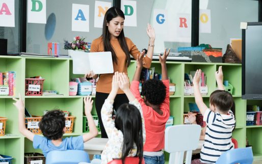 Young asian woman teacher teaching kids in kindergarten classroom, preschool education concept