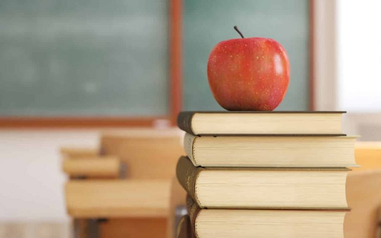 3d rendering. one apple on books in empty school classroom. education concept