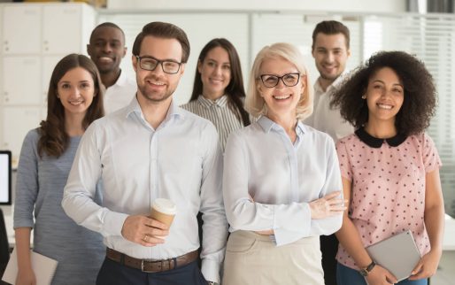 Smiling professional business coaches leaders mentors posing together with diverse office workers interns group, happy multicultural staff corporate employees people looking at camera, team portrait