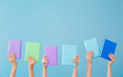 Female hands with books on color background