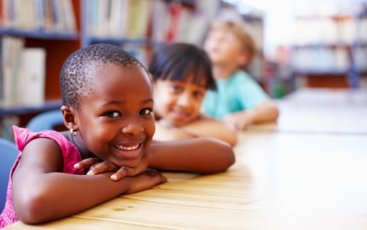 Closeup portrait of children resting their heads on the library table