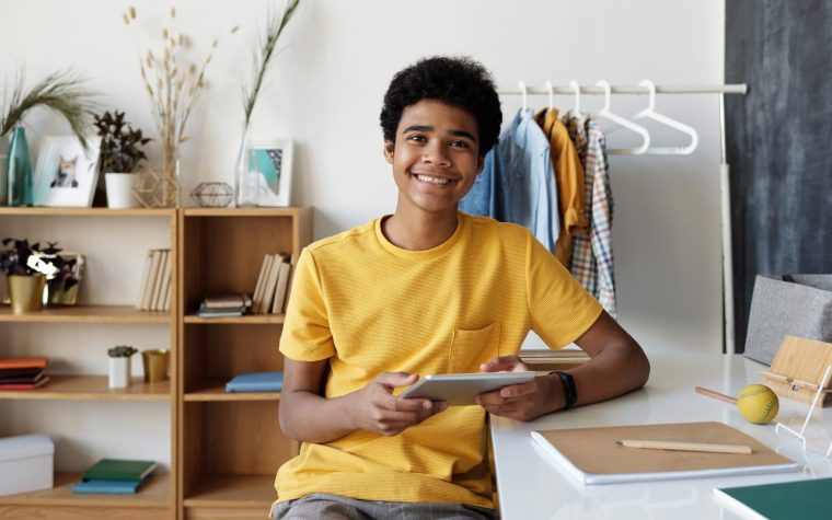 boy-in-yellow-crew-neck-t-shirt-sitting-on-chair-4144099