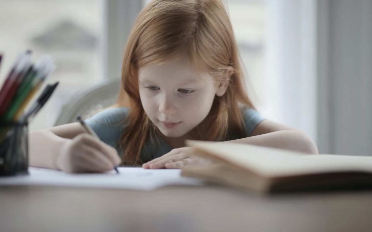 clever-concentrated-little-girl-doing-homework-at-home-3887251