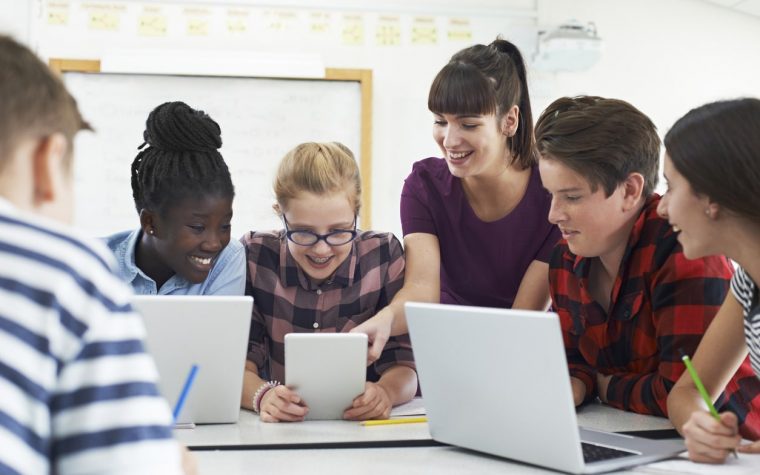 Teenage Students With Teacher In IT Class