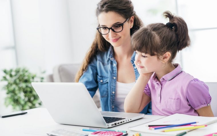 Young teacher and cute girl using a laptop together and connecting online, technology and entertainment concept