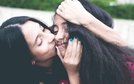 woman-kissing-cheek-of-girl-wearing-red-and-black-polka-dot-1101730